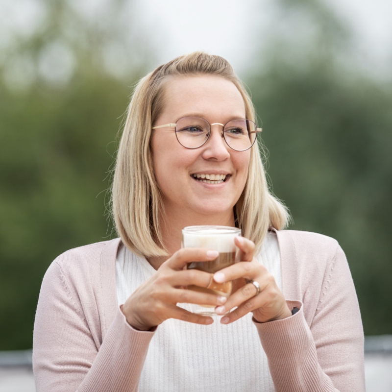 Optitime Mitarbeiterin Andrina van Dijk mit einem Kaffee